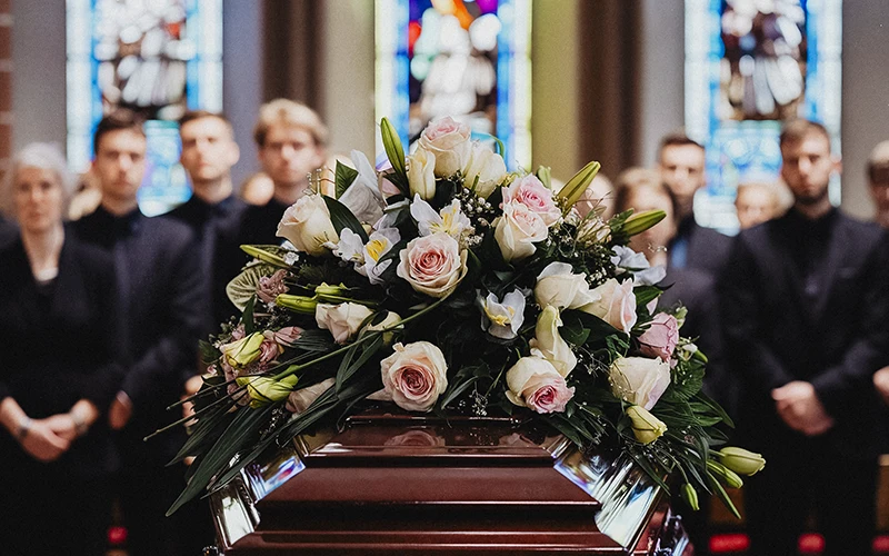 Trauerfotografie Rastatt Baden-Baden. Trauergäste am Sarg bei einer Trauerfeier.