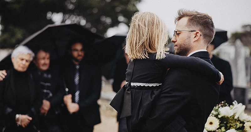 Trauerfotografie Rastatt Baden-Baden. Trauergäste am Sarg bei einer Beisetzung.